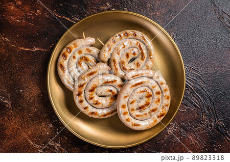 Bavarian Roasted spiral pork meat sausages with herbs. Dark background. Top view Bavarian Roasted spiral pork meat sausages with herbs. Dark background. Top view 89823318