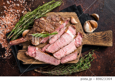 BBQ Grilled Tomahawk Steak, Rib eye on a wooden board. Dark background. Top view 89823364