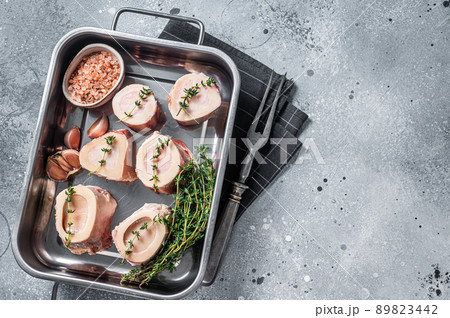 Raw beef Marrow bones in kitchen tray ready for cooking. Gray background. Top view. Copy space 89823442