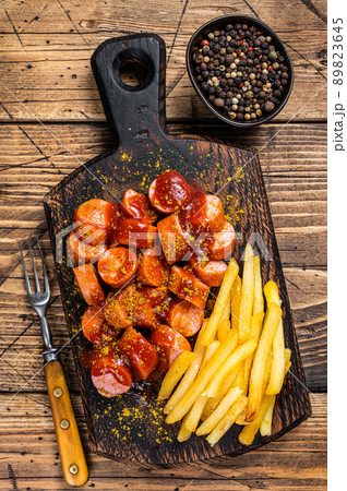 Curry wurst Sausages with French fries on a wooden board. wooden background. Top view Curry wurst Sausages with French fries on a wooden board. wooden background. Top view 89823645