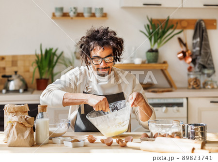 Black man cooking pastry in kitchen at home 89823741
