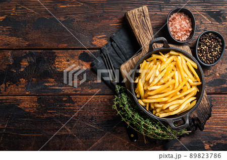 Skilet full of Potato french fries with salt. Wooden background. Top view. Copy space Skilet full of Potato french fries with salt. Wooden background. Top view. Copy space 89823786