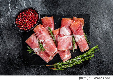 Traditional Spanish Jamon Serrano ham on marble board. Black background. Top view 89823788