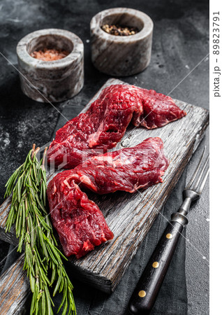Flap steak flank raw cut and Machete skirt steak on wooden board. Black background. Top view 89823791