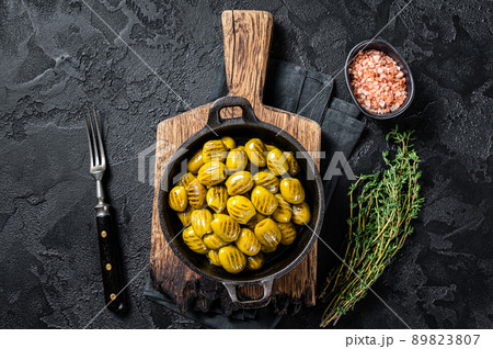 BBQ Grilled olives with garlic, olive oil and spices. Black background. Top view BBQ Grilled olives with garlic, olive oil and spices. Black background. Top view 89823807
