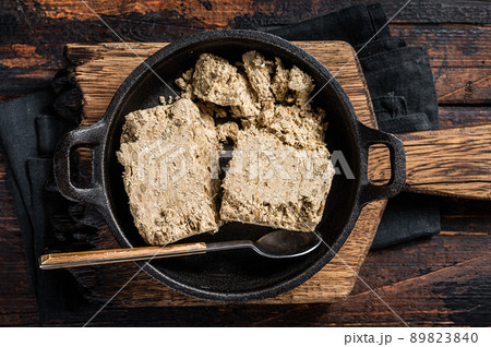 Halva with sunflower seeds and honey in pan. Wooden background. Top view 89823840