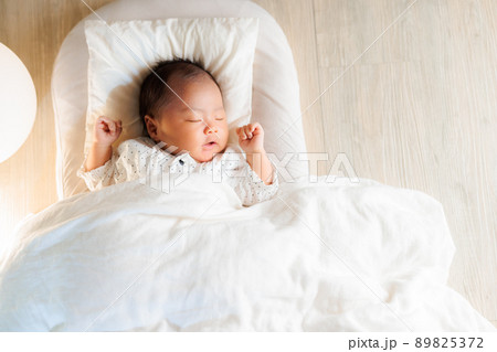 夜 両腕をあげて眠る赤ちゃん バンザイ寝 コピースペースの写真素材 5372