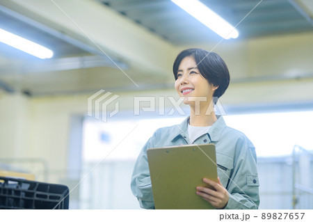 荷物を確認する作業着の棚卸中の女性作業員 89827657