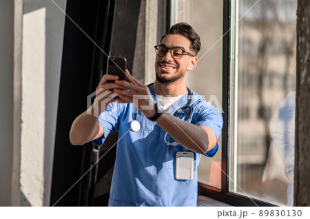 Cheerful doctor in uniform taking a selfie 89830130
