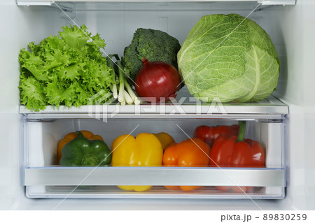 Open refrigerator full of fresh vegetables, closeup 89830259