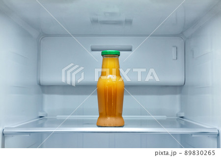 Bottle of juice on shelf in refrigerator Bottle of juice on shelf in refrigerator 89830265