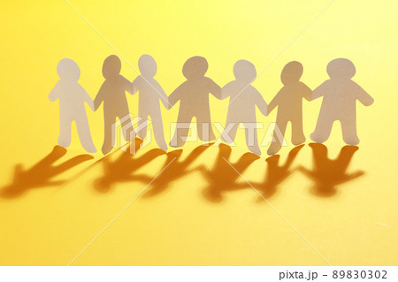Paper people chain on yellow background. Unity concept 89830302
