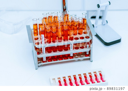 close up. tubes of red liquid in a stand on the lab table. 89831197