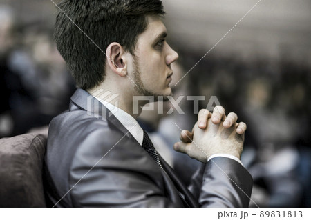 closeup of a young successful businessman on a business conference, sitting in the conference room closeup of a young successful businessman on a business conference, sitting in the conference room 89831813