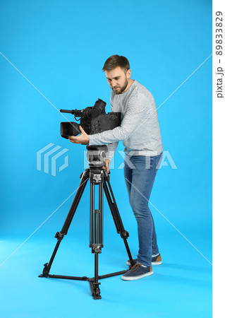 Operator with professional video camera on blue background 89833829