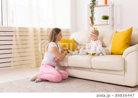 Child girl with cochlear implant with her mother at home. Hear impairment and deaf community and diversity concept 89836447