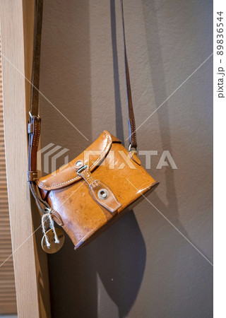 Close-up of yellow leather bag hanging against wall in empty hotel room 89836544