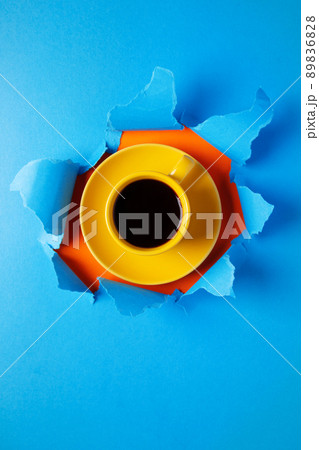 Cup of coffee in torn paper. Coffee espresso on jeans background 89836828