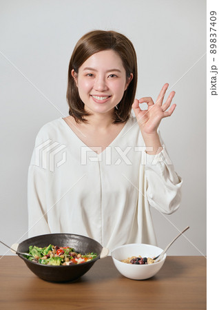 サラダとオートミールを食べる前にOKのポーズをする若い女性 サラダとオートミールを食べる前にOKのポーズをする若い女性 89837409