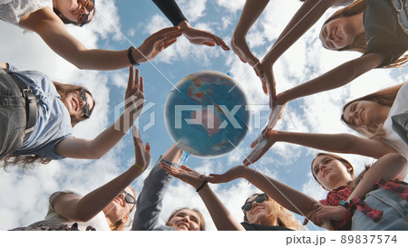 Earth conservation concept. 11 girls surround the rotating earth globe with their palms. Earth conservation concept. 11 girls surround the rotating earth globe with their palms. 89837574