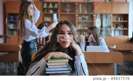 A student poses with textbooks at her desk in her class. A student poses with textbooks at her desk in her class. 89837576