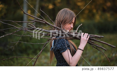 Young girl posing with brushwood for a fire on a picnic. 89837577