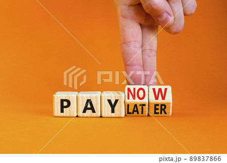 Pay later or now symbol. Businessman turns wooden cubes and changes concept words Pay later to Pay now. Beautiful orange table orange background. Business pay later or now concept. Copy space. 89837866