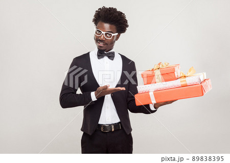 Valentine day concept. African businessman pointing hand at red box. Studio shot, gray background 89838395