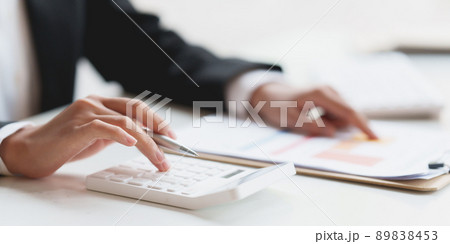 Asian Business Woman or Accountant do math and analyze with calculator and paperwork on desk, account, consult, audit and saving concept. Asian Business Woman or Accountant do math and analyze with calculator and paperwork on desk, account, consult, audit and saving concept. 89838453