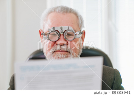 making a selection of lenses, diagnosing a elderly man's vision. making a selection of lenses, diagnosing a elderly man's vision. 89838941
