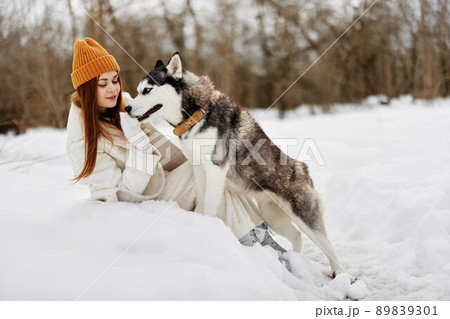 woman in the snow playing with a dog outdoors friendship Lifestyle 89839301