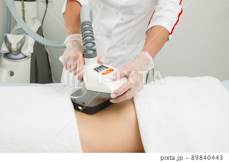 A woman undergoes an anti-cellulite procedure in a cosmetology clinic. 89840443