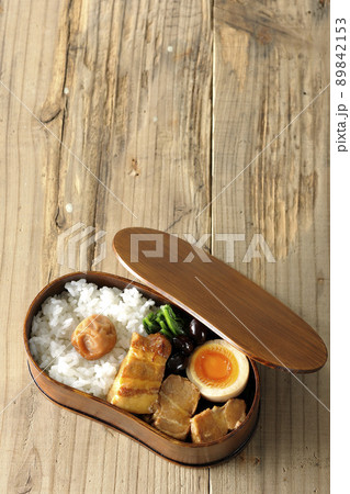 曲げわっぱに黒豆やほうれん草、半熟卵が入っている角煮弁当を俯瞰で撮影 曲げわっぱに黒豆やほうれん草、半熟卵が入っている角煮弁当を俯瞰で撮影 89842153