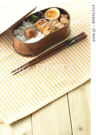 曲げわっぱに黒豆やほうれん草、半熟卵が入っている角煮弁当 89842334