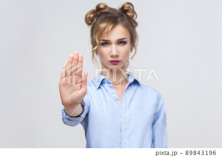 Blonde woman with bad attitude making stop gesture with her palm outward, saying no, expressing denial or restriction. Studio shot Blonde woman with bad attitude making stop gesture with her palm outward, saying no, expressing denial or restriction. Studio shot 89843196