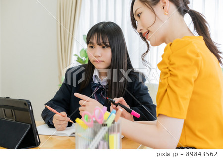 リビングでレッスンをする家庭教師と受験生 89843562