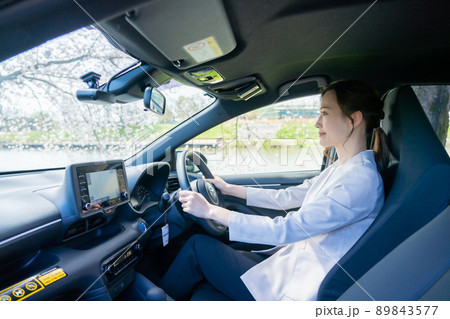 車を運転する若い女性 89843577