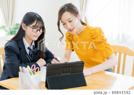 リビングでレッスンをする家庭教師と受験生 89843592