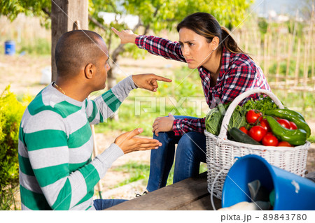 Couple quarreling in homestead garden in spring day Couple quarreling in homestead garden in spring day 89843780