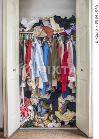 messy closet overfilled with clothes messy closet overfilled with clothes 89845045