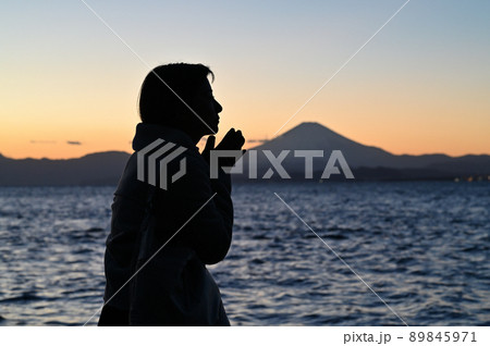 冬の夕暮れの富士山と女性 89845971