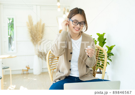 Young woman using wireless headphone listening to music. Young woman using wireless headphone listening to music. 89846567