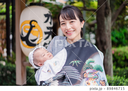 外で赤ちゃんを抱っこするお母さん 外で赤ちゃんを抱っこするお母さん 89846715