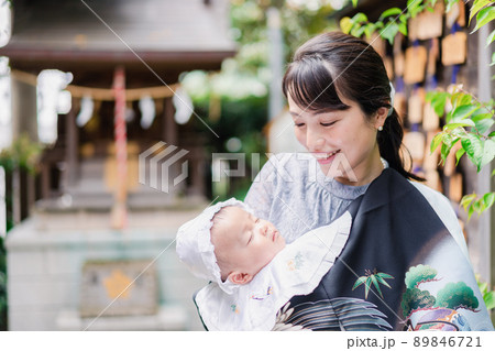 外で赤ちゃんを抱っこするお母さん 外で赤ちゃんを抱っこするお母さん 89846721