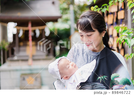 外で赤ちゃんを抱っこするお母さん 89846722