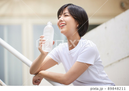 ペットボトルの水を飲む若い女性 89848211