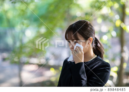 お葬式でハンカチを持って泣く女性 89848485