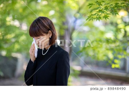 お葬式でハンカチを持って泣く女性 89848490