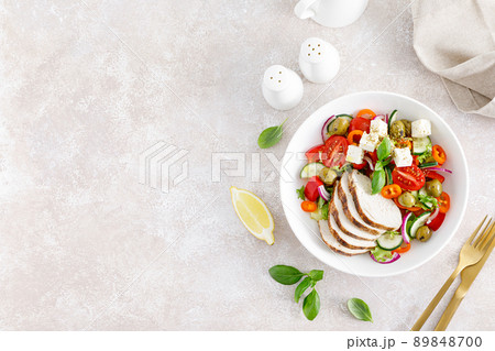 Grilled chicken breast and fresh greek salad with feta cheese. Top view 89848700