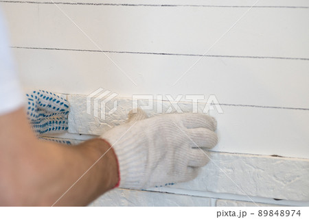 Professional Builder gluing decorative tile on wall. worker mounts decorative brick on wall Professional Builder gluing decorative tile on wall. worker mounts decorative brick on wall 89848974